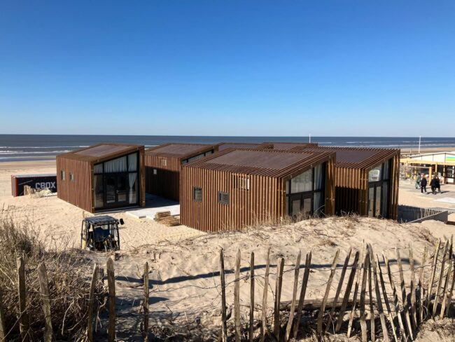 Moderne strandhuisjes in Zandvoort met bruine UniKern® gevelbekleding achter houten latten