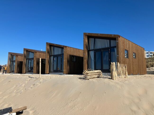 Moderne strandhuisjes in Zandvoort met bruine UniKern® gevelbekleding achter houten latten