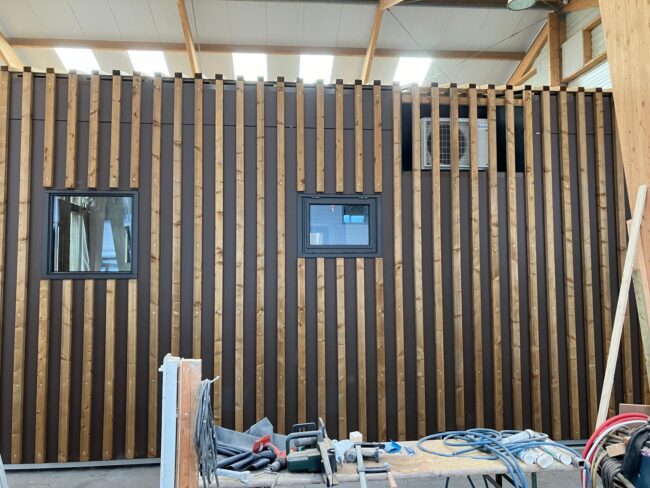 Moderne strandhuisjes in Zandvoort met bruine UniKern® gevelbekleding achter houten latten