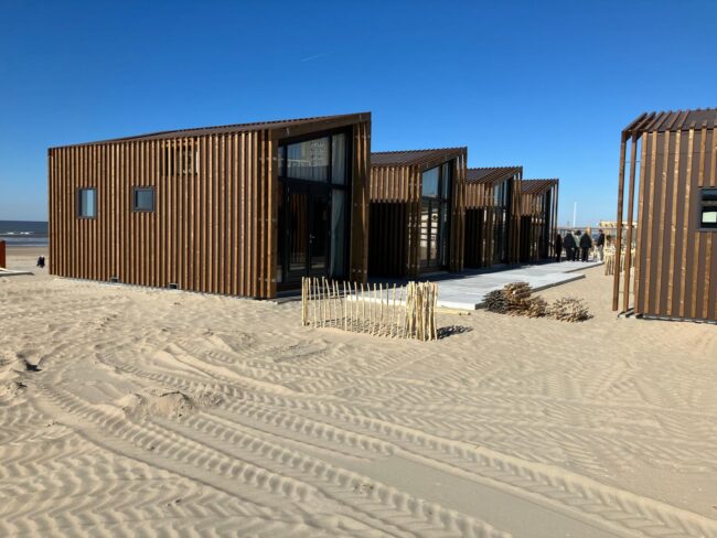 Moderne strandhuisjes in Zandvoort met bruine UniKern® gevelbekleding achter houten latten