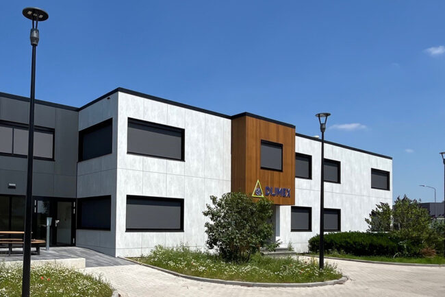 Modern pand met licht- en donkergrijze UniKern® gevelbekleding en houtlook entree.