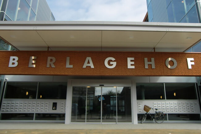 Zwevende luifel met ivoorkleurige UniKern® biobased compactplaten bij appartementen in Rotterdam