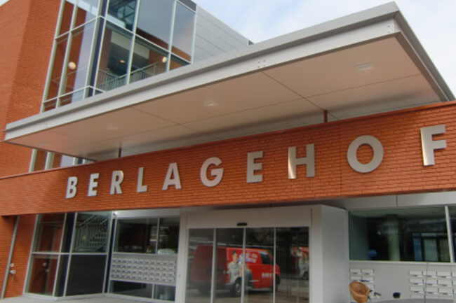 Zwevende luifel met ivoorkleurige UniKern® biobased compactplaten bij appartementen in Rotterdam