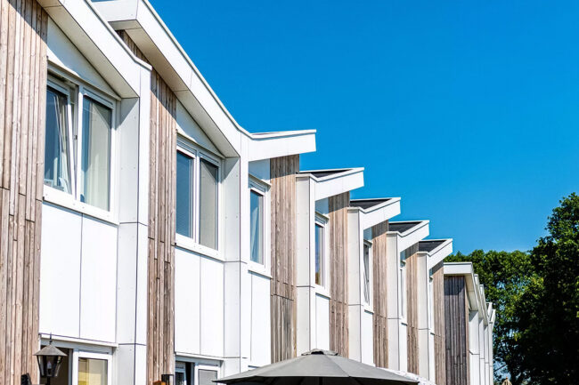 Prefab woningen in Erp met houten gevelbekleding en UniKern® gevelaccenten in wit en antraciet.